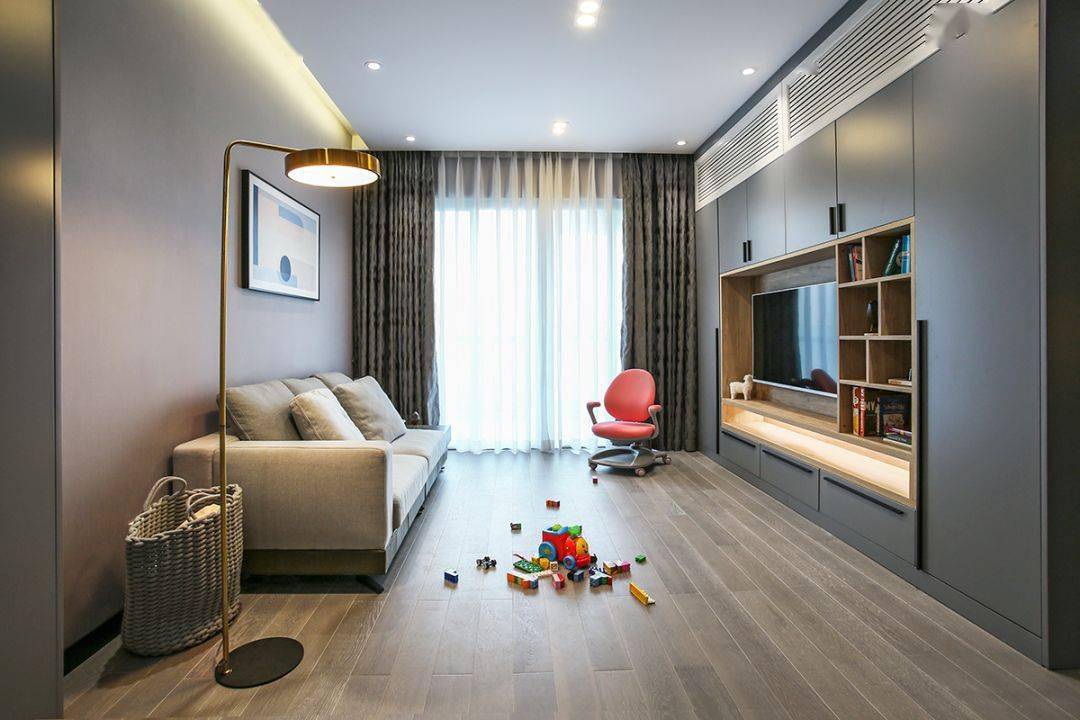 今天分享的是一套建筑面積102平米的現代輕奢風三居室案例，屋主夫妻和女兒、母親一家四口人居住，整體來說是比較緊湊的剛需三房案例，設計師以輕松、時尚的灰色調作為主色，搭配格調滿滿的木質家具，營造出簡約、輕奢的感覺。    平面布置圖    入戶玄關和餐廳連在了一起，利用了入戶門側方的墻面來做上一整墻的柜子，把鞋柜和餐邊柜結合在一起使用，更為省空間。    復古的木質餐桌椅到灰色調的背景，金屬質感的吊燈，整個餐廳看起來非常有格調感。在餐桌椅側方加上隔板的設計，增強儲物能力。    位于餐廳另一側的就是客廳空間了，客廳的茶幾被舍棄，中間留空方便作為孩子的娛樂區，米色布藝沙發和暖灰色背景墻讓人感覺更加溫馨。    客廳的電視背景墻則是被利用起來做了收納，整墻的柜子留空電視周邊的部分區域，加上藏光之后使用更方便，看起來也更大氣。    廚房內部的櫥柜延續了客餐廳的柜子顏色，深灰色的大理石墻磚搭配灰色的啞光地磚，整個廚房看起來很有現代感。    臥室選擇了以藍灰色為主，在臥室頂部吊頂內加上藏光，用吊燈、臺燈等代替主燈，讓臥室看起來更為簡潔。    在主臥室里還有一個迷你的衣帽間，U字形布局的柜子把角落空間充分用上。衣帽間外的床頭柜改成了梳妝臺，使用起來更加方便。    老人房選擇了榻榻米床組合衣柜和書桌的設計，榻榻米的安全性會更高一些，加上一張書桌也方便屋主母親看看書。    衛生間內部是三角形的布局方案，鉆石形的淋浴房做在了轉角處，兩側擺放洗手臺和馬桶。洗手臺上方的鏡柜做了藏光的設計，看起來更時尚。